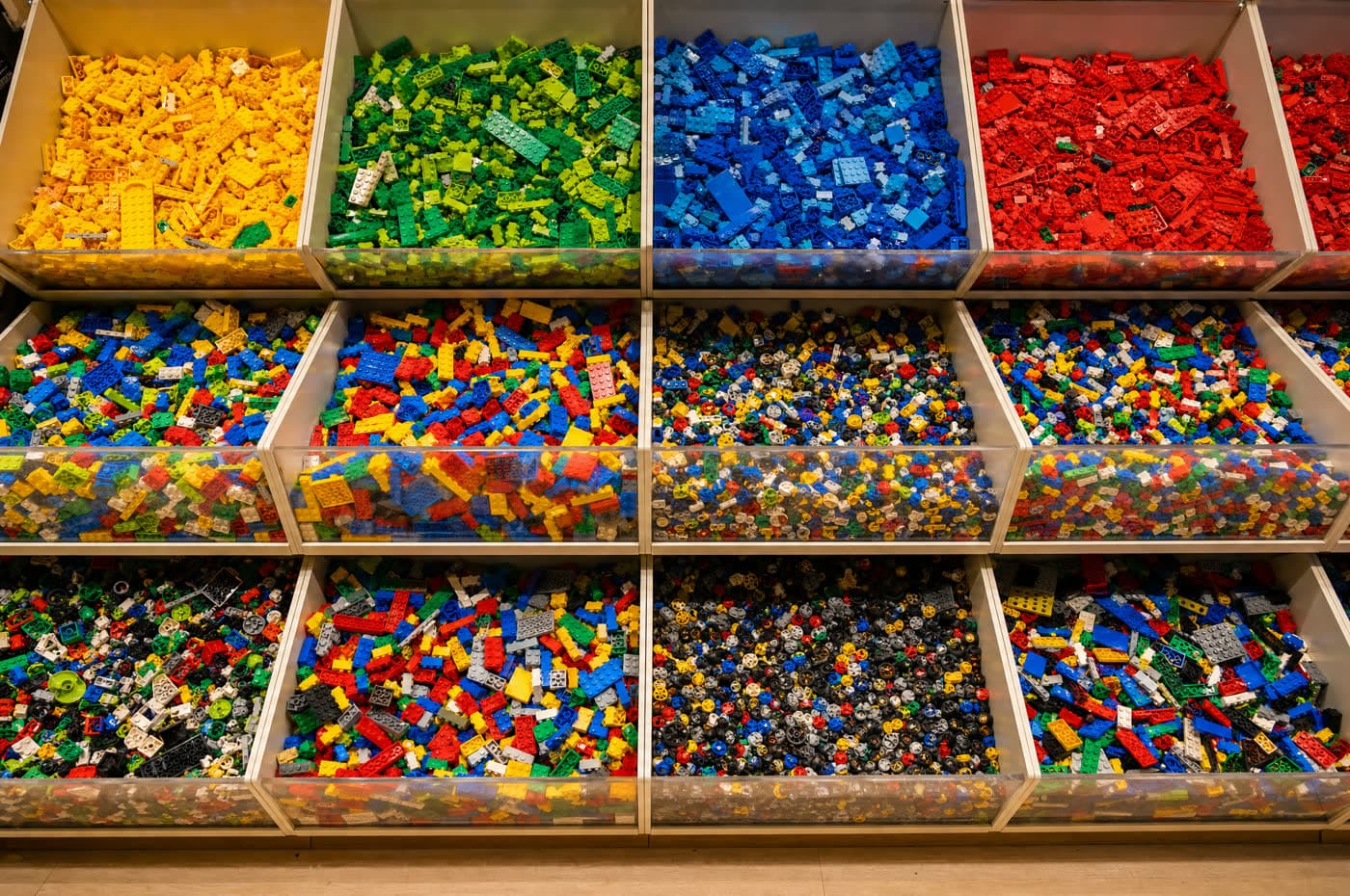 Bins overflowing with thousands of colorful loose building bricks